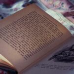 An open vintage book resting on a floral bedspread, evoking a cozy and nostalgic atmosphere.